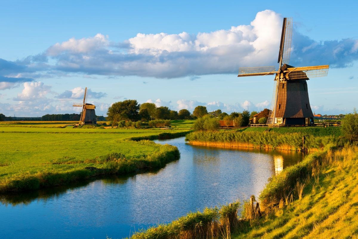 Nederlands polderlandschap met twee molens langs een vaart